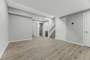 Spruce Grove apartment for rent - A spacious room with wooden flooring and white walls.