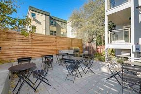 Seattle apartment for rent - A patio with a table and chairs is surrounded by a wooden fence.