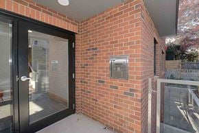 Seattle apartment for rent - A brick wall with a black door and a small window.