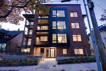 Seattle apartment for rent - A modern apartment building with a dark blue facade and a black door.