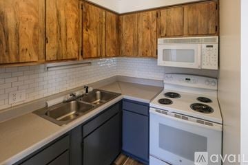 Athens apartment for rent - A kitchen with wooden cabinets and a white stove.