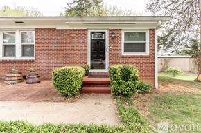 Hickory apartment for rent - A red brick house with a black door and two windows.