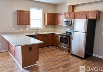 Cincinnati apartment for rent - A kitchen with wooden cabinets and a stainless steel refrigerator.