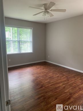Cincinnati apartment for rent - A room with wooden floors and a ceiling fan.