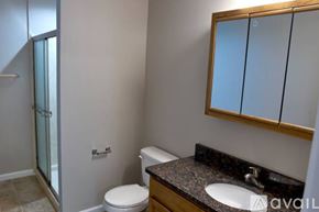 Cincinnati apartment for rent - A bathroom with a toilet, sink, and mirror.