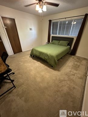 Houston house for rent - A bedroom with a bed, desk, and window.