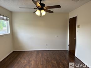 Houston house for rent - A bedroom with a bed, a ceiling fan, and a wall-mounted shelf.