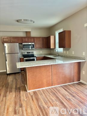 Cincinnati apartment for rent - A kitchen with wooden cabinets and a stainless steel refrigerator.