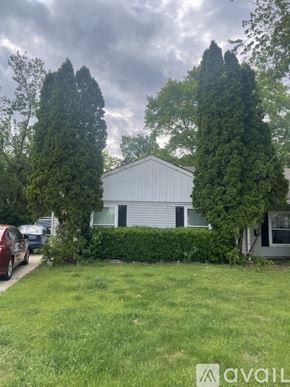 Bartlett apartment for rent - A house with a white garage door is surrounded by greenery and trees.