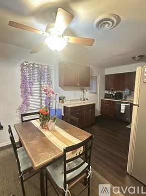 Bartlett apartment for rent - A kitchen with a table and chairs in the foreground and a refrigerator in the background.