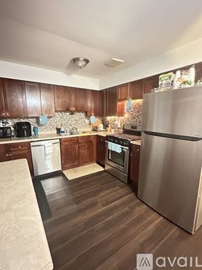 Bartlett apartment for rent - A kitchen with wooden cabinets and a stainless steel refrigerator.