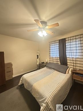 Bartlett apartment for rent - A bedroom with a bed, a ceiling fan, and a window with curtains.