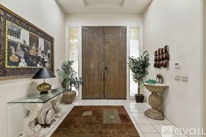 Indian Wells house for rent - A hallway with a brown rug, a glass table, a lamp, and a framed picture on the wall.