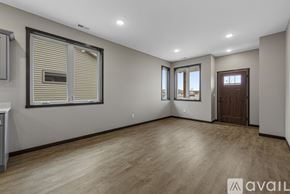 Saint Peter townhouse for rent - A spacious room with wooden flooring and a large window with blinds.