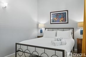 Richardson house for rent - A bedroom with a white bed and a picture frame on the wall.