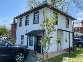 Charlottesville apartment for rent - A white house with a black roof and a tree in front.