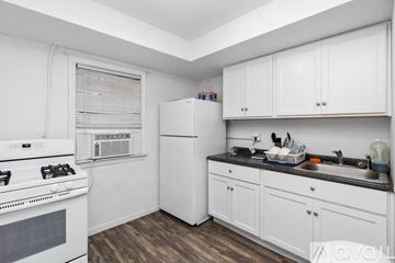Charlottesville apartment for rent - A kitchen with white cabinets and a black countertop.
