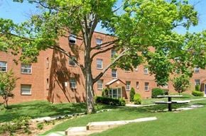 Falls Church apartment for rent - a large brick building with a tree in front of it