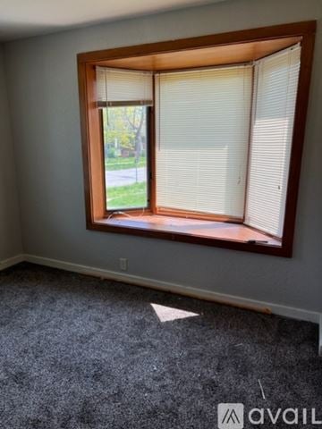 Red Wing apartment for rent - A room with a carpeted floor and a window with blinds.