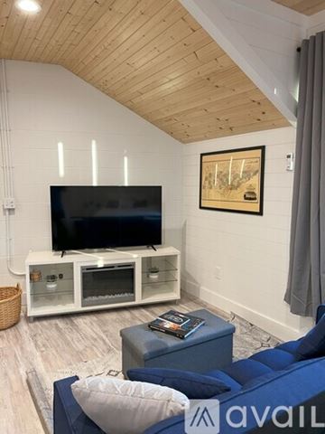 Pleasant View apartment for rent - A living room with a blue couch and a television on a white stand.