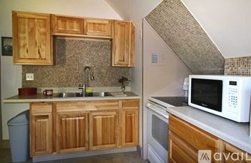 Conway apartment for rent - A kitchen with wooden cabinets and a white microwave.