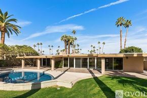 Indian Wells house for rent - A house with a pool and palm trees in the background.