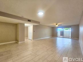 Phoenix townhouse for rent - A spacious room with wooden flooring and a door leading to another room.