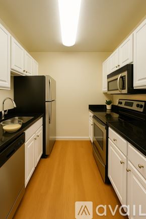 San Francisco apartment for rent - A kitchen with black appliances and white cabinets.