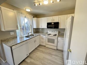 Aurora house for rent - A kitchen with white cabinets and a granite countertop.