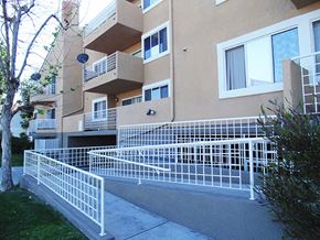 Paramount apartment for rent - the façade of an apartment building with white fences