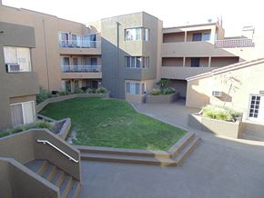 Paramount apartment for rent - an apartment building with a lawn in the middle of it