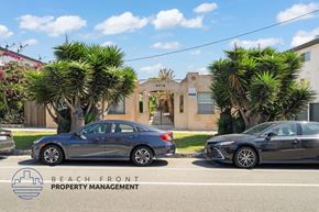 San Pedro apartment for rent - Two cars parked in front of a building with the logo of Beach Front Property Management.
