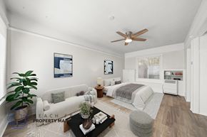 San Pedro apartment for rent - A well-lit, spacious living room with a white sofa, a grey ottoman, and a coffee table.