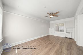 San Pedro apartment for rent - A room with a ceiling fan and wooden flooring.