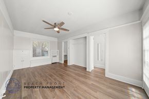 San Pedro apartment for rent - A spacious room with a ceiling fan and wooden flooring.