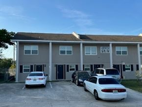Deltona apartment for rent - A white car is parked in front of a building.