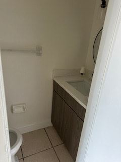 Deltona apartment for rent - A white toilet is in a small bathroom with a sink and a mirror.