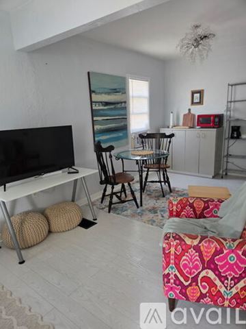 Daytona Beach house for rent - A living room with a red and white patterned chair in the foreground.