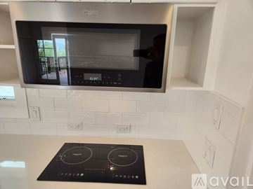 Vista apartment for rent - A modern kitchen with a Whirlpool microwave oven mounted above a stove top.