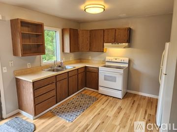 Mount Pleasant house for rent - A kitchen with wooden cabinets and a white stove top oven.