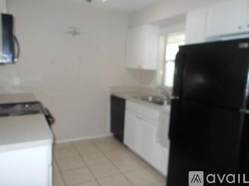 Fort Myers house for rent - A black refrigerator is in the kitchen.