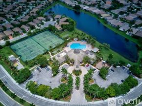 West Palm Beach house for rent - An aerial view of a neighborhood with a tennis court and a pool.