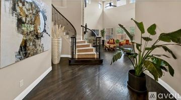 Mckinney house for rent - A living room with a staircase and a large painting on the wall.