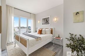 Brooklyn apartment for rent - A bedroom with a large bed and a view of the city through the window.