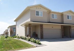 West Fargo townhouse for rent - a beige house with a driveway and a lawn