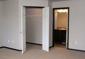 West Fargo townhouse for rent - an empty bedroom with a closet and a mirror
