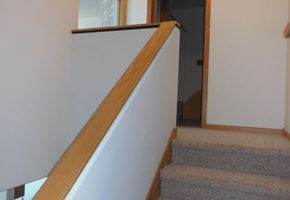 West Fargo townhouse for rent - a set of stairs with a wooden railing and a white wall