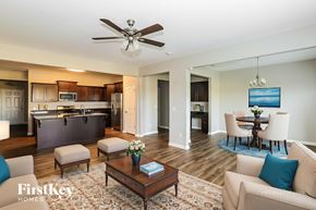 Statesville house for rent - A well-lit living room with a dining area in the background.