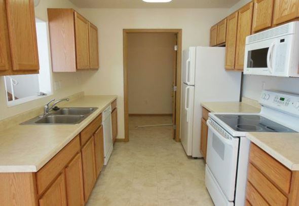 Moorhead townhouse for rent - a kitchen with a stove and a sink and a refrigerator