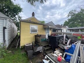 Louisville house for rent - A yellow house with a lot of junk in front of it.